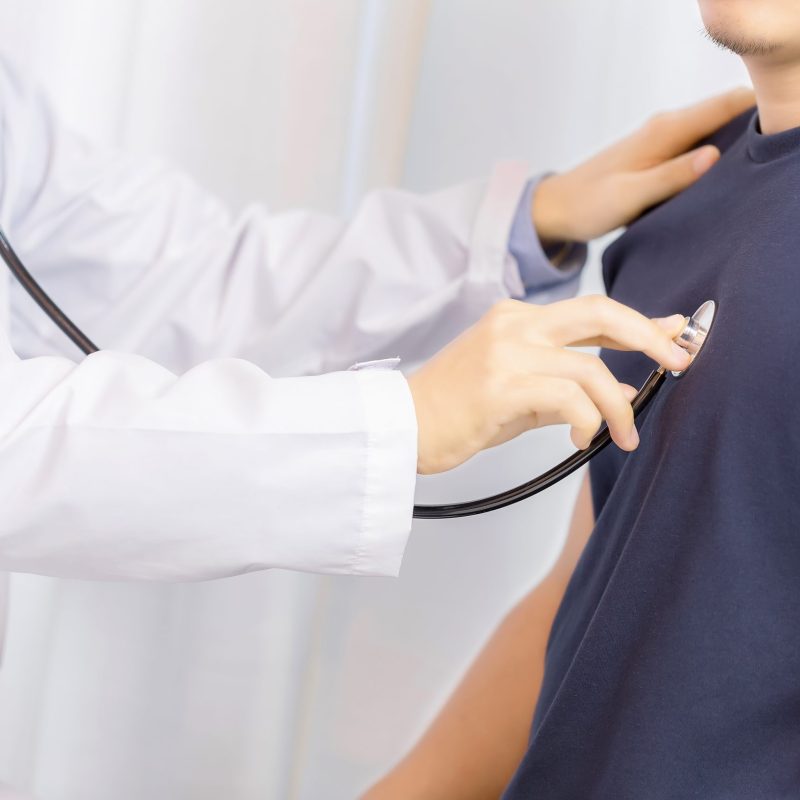 Doctor examination young man with stethoscope in hospital. healthcare and medicine